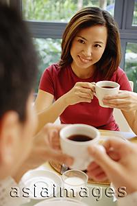Asia Images Group - Couple facing each other, holding cups of coffee
