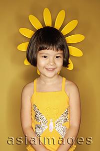 Asia Images Group - Young girl standing against yellow background