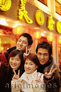 Asia Images Group - Young adults smiling at camera making peace signs