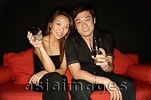 Asia Images Group - Couple with drinks, looking at camera
