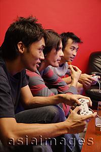Asia Images Group - Young men holding video game controllers
