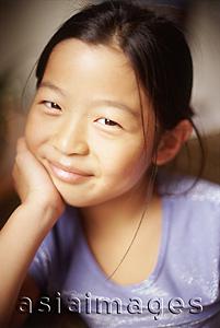 Asia Images Group - Young girl, hand on chin, looking at camera