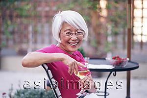Asia Images Group - Mature woman holding wine glass, looking at camera