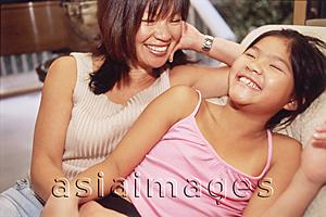 Asia Images Group - Mother and daughter sitting side by side, smiling