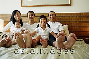 Asia Images Group - Three generation family on bed, looking at camera, low angle view