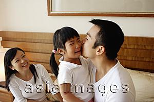 Asia Images Group - Father kissing crying daughter, mother looking on