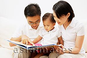 Asia Images Group - Family with one child, looking at book