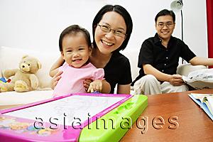 Asia Images Group - Family with one child in living room, looking at camera, portrait