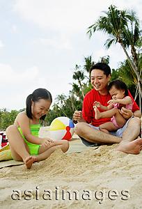 Asia Images Group -  Father with two children playing on beach