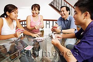 Asia Images Group - Family at home, playing cards around table