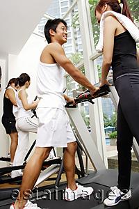 Asia Images Group - Couples in gym, walking on treadmill