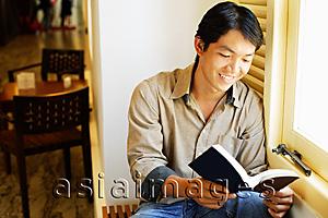 Asia Images Group - Man reading book, smiling