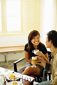 Asia Images Group - Couple at cafe, holding coffee mugs, food on table