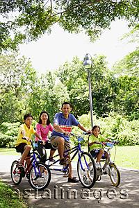 Asia Images Group - Family with two children, on bicycles, portrait
