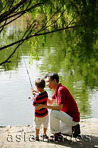 Asia Images Group - Father teaching son to hold fishing pole