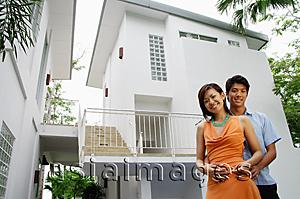 Asia Images Group - Couple looking at camera, house behind them