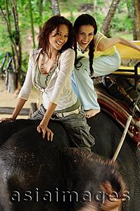 Asia Images Group - Two young women riding on elephant, Phuket, Thailand