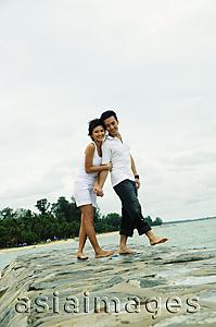 Asia Images Group - Couple standing on breakwater, smiling at camera