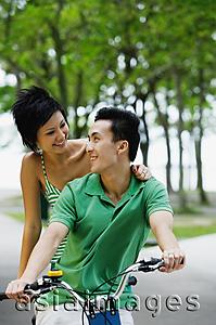 Asia Images Group - Couple on tandem bicycle, looking at each other