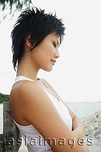 Asia Images Group - Woman in sleeveless top, eyes closed, arms crossed