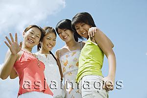 Asia Images Group - Young women standing side by side, looking at camera, smiling