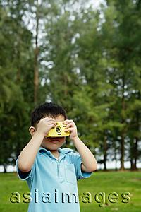 Asia Images Group - Young boy in park using camera