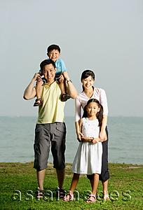 Asia Images Group - Family of four, standing by sea, family portrait