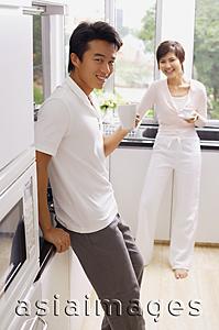 Asia Images Group - Couple in kitchen, having coffee, smiling at camera