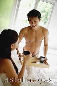Asia Images Group - Man bringing woman breakfast in bed