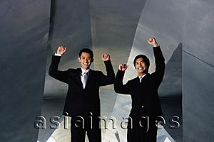 Asia Images Group - Two businessmen looking at camera, hands raised in the air