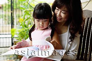 Asia Images Group - Grandmother and granddaughter looking at book
