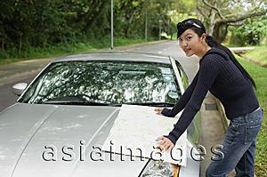 Asia Images Group - Woman with map, standing next to car, looking at camera