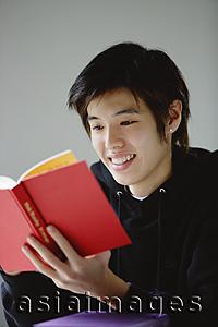 Asia Images Group - Young man reading book