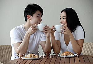 Asia Images Group - Couple having breakfast, smiling at each other
