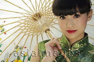 Asia Images Group - Head shot of young woman in Chinese traditional dress holding an umbrella