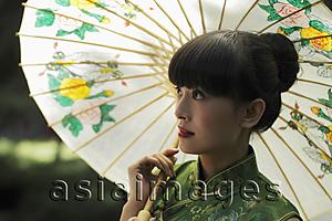 Asia Images Group - Young woman wearing a Chinese traditional dress and holding an umbrella