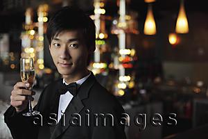 Asia Images Group - Young man in a tuxedo holding a glass of champagne