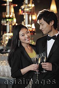 Asia Images Group - Young couple dressed up toasting with champagne glasses