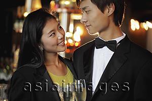 Asia Images Group - Young couple dressed up at night, looking at each other