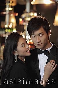 Asia Images Group - Young woman looking at young man in a tuxedo.