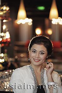 Asia Images Group - Head shot of elegantly dressed woman with diamond jewelry at night