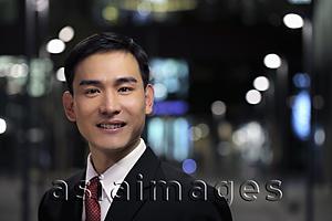 Asia Images Group - Man wearing business suit standing on the street at night