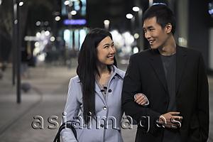 Asia Images Group - Young couple wearing coats walking on the street at night