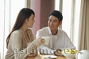 Asia Images Group - Young couple drinking coffee together in their home