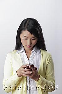 Asia Images Group - Young woman texting on her phone