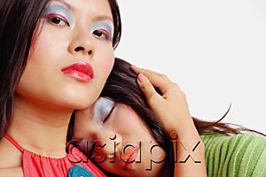 AsiaPix - Woman looking at camera, another woman leaning on her shoulder, eyes closed