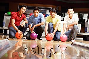 AsiaPix - Four men crouching in bowling alley, holding bowling balls