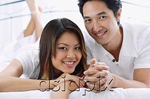 AsiaPix - Couple side by side on bed, smiling