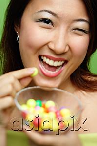 AsiaPix - Woman holding candy and candy bowl, winking