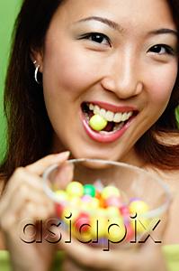 AsiaPix - Woman biting candy and holding candy bowl